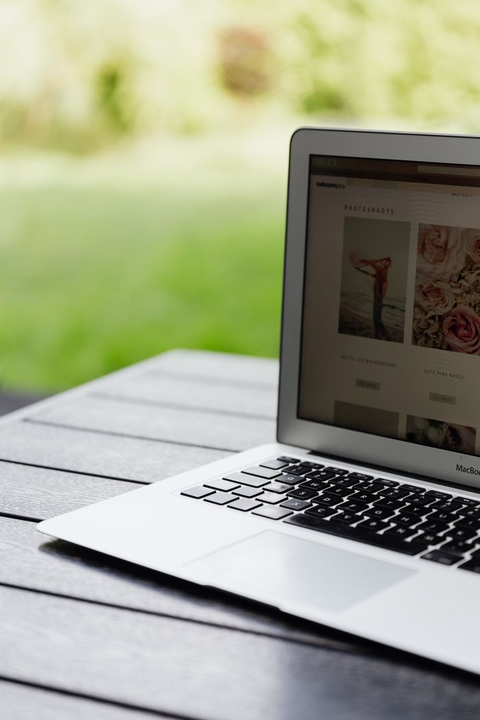 Home Close-up of an open laptop on a table displaying a website outdoors.